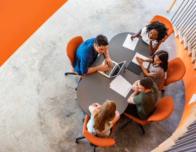 4 pessoas sentadas em uma sala de reunião vistas de cima