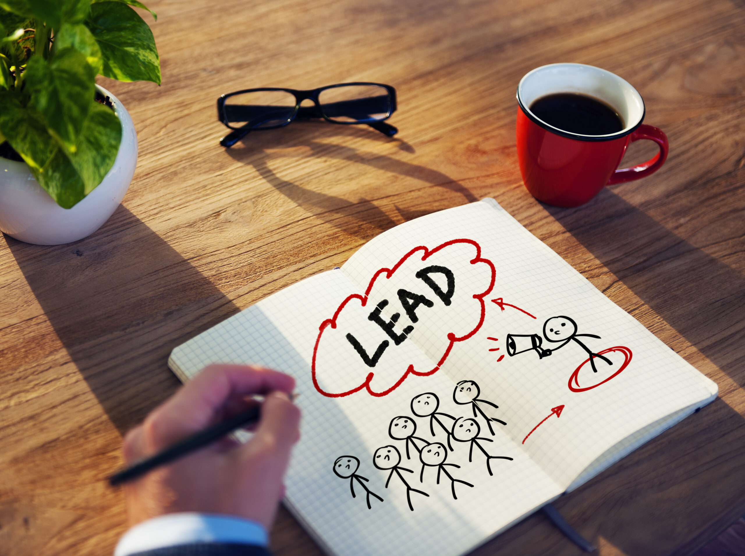 Profissional desenhando diagrama de funil de qualificação de leads em caderno, mostrando conversão de audiência em leads qualificados