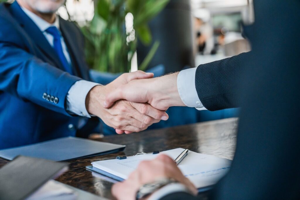 Aperto de mãos entre executivos em reunião de negócios fechando acordo comercial
